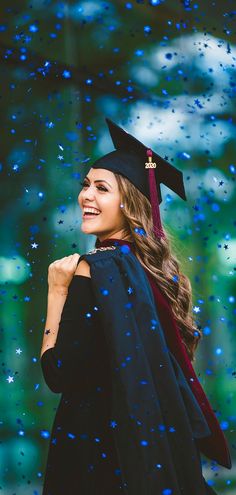 a woman in graduation cap and gown is smiling at the camera with rain falling on her