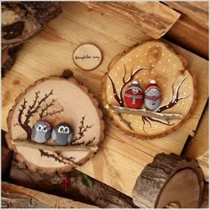 two small owls sitting on top of wooden slices