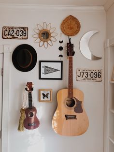 there is a guitar hanging on the wall next to other items and decor in this room