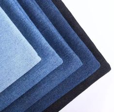 blue and black rugs are stacked on top of each other