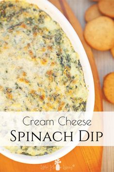 a white bowl filled with spinach dip next to crackers