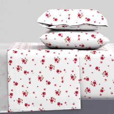 three pillows stacked on top of each other with red flowers all over the pillow cases