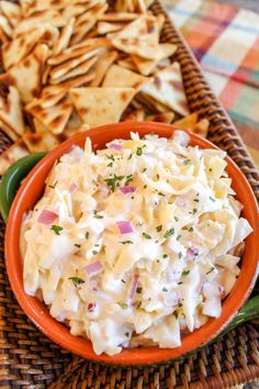 a bowl filled with coleslaw and crackers on top of a woven table cloth