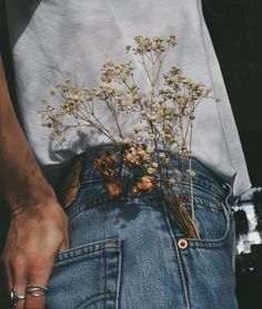 a person wearing jeans with flowers in their pockets