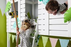 a young boy is playing with a monkey mask on his head while hanging from a rope