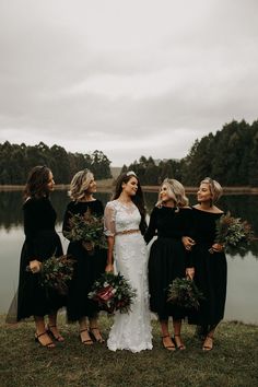 a group of women standing next to each other on top of a grass covered field