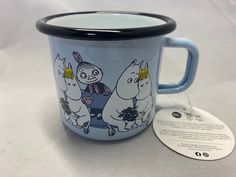 a blue mug with moomi characters on it and a tag attached to the cup