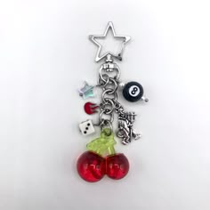 a keychain with charms attached to it on a white surface, including dices and balls