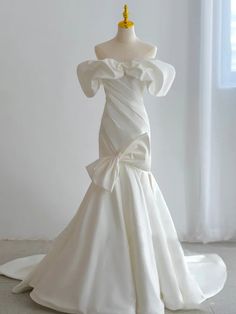 a white wedding dress on display in front of a window