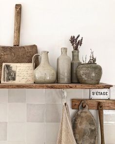 some vases and other items are on a shelf in the corner of a room