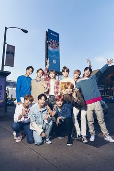 a group of young men posing for a photo in front of a sign and building