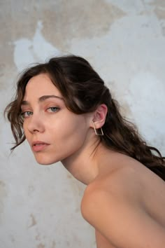 a woman with no shirt on is posing for the camera and has her hair pulled back