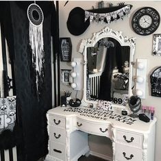 a white vanity with black and white decorations on it's walls, including a clock