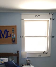 a bedroom with blue walls and white bedding has measurements for the size of the window