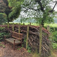 a wooden bench sitting next to a pile of branches