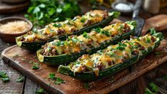 zucchini stuffed with meat and cheese on a cutting board next to other food