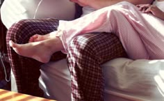 a woman laying on top of a bed next to a man with headphones in his ears