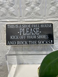 a sign that says, this is a shoe free house please kick off your shoes and rock the socks