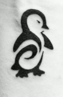 a small black and white penguin tattoo on the back of a person's arm