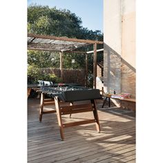 an outdoor table is set up on the deck for two people to play foo - pong