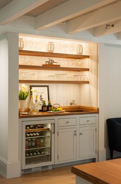 a kitchen with white cabinets and wooden shelves