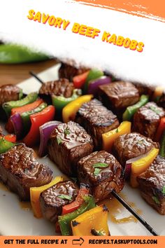 steak kabobs on skewers with peppers and bell peppers in the foreground