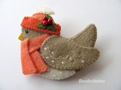 a felt bird ornament with a red hat and scarf