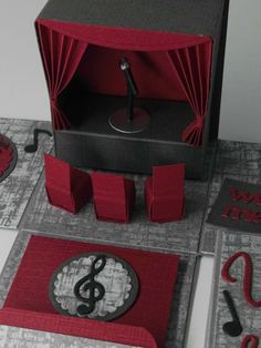 an open box with music notes on it and red paper cutouts around the inside