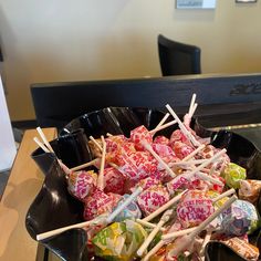 a bowl full of candy sticks sitting on top of a table