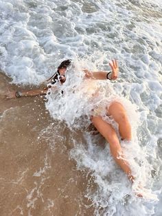 a woman laying on her stomach in the ocean