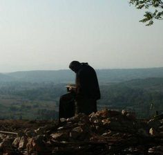 a man sitting on top of a pile of rocks