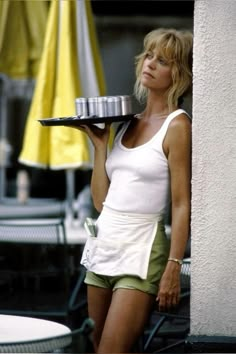 a woman holding a tray with a cake on it