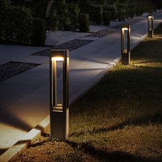 some lights that are on the side of a road in the grass at night time