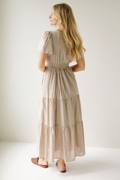 The 'Athena' dress is the perfect feminine staple to add to your closet! Easily transitioned throughout the year, the dress comes in a neutral taupe color, or a pretty merlot shade. The dress features flutter sleeves, an elastic waistband, tiered skirt, and dainty embroidered details on the front! 60% Cotton, 40% Polyester Shell 100% Polyester Lining Fully Lined Hand Wash Cold Hang or Lay Flat to Dry Do Not Bleach Low Iron If Needed Model in Merlot Height 5'9" | Wearing Size Small Model in Taupe Modest Beige V-neck Dress, Modest Beige Maxi Dress, Beige Short Sleeve Maxi Dress For Fall, Cream Short Sleeve Dress For Fall, Modest Beige Maxi Dress With Short Sleeves, Spring Taupe V-neck Dress, Modest Flowy Beige Dress, Beige Spring Dress With Natural Waistline, Taupe Fitted V-neck Dress