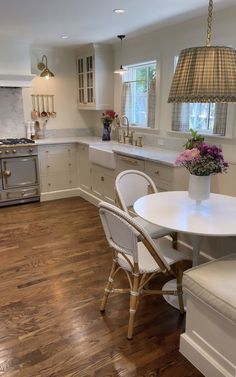 a kitchen with a table and chairs next to a stove top oven in the corner