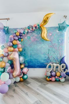 an ocean themed birthday party with balloons and under the sea theme, including one letter balloon arch