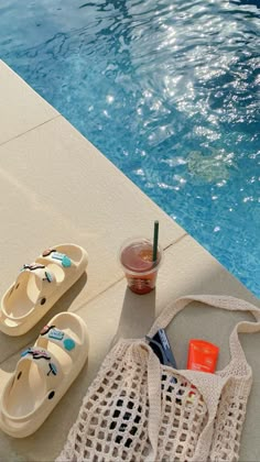 a pair of sandals and a bag next to a swimming pool