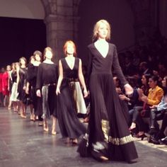 models walk down the runway in black dresses