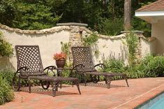 three patio chairs sitting next to a swimming pool in a backyard with brick pavers