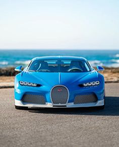 a blue bugatti is parked on the road near the ocean