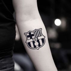 a woman's arm with a tattoo on it that has a soccer ball in the center