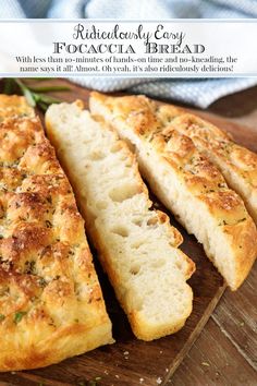 the bread is sliced and ready to be eaten on the cutting board with herbs around it