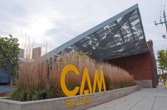 there is a large yellow sign in front of the building that says ca m on it