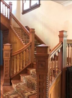 a staircase with wooden handrails and carpeted stairs