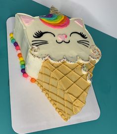 a cake shaped like an ice cream cone with a cat's face on top