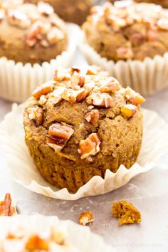 several muffins sitting on top of each other with pecans in the background