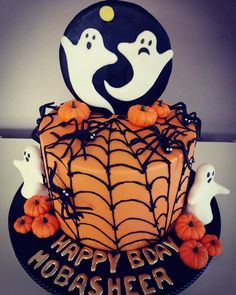 a halloween cake decorated with spider web and ghost faces