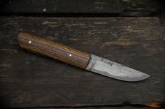 a knife with a wooden handle sitting on top of a table