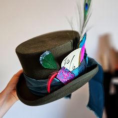 a person holding a hat with feathers on it