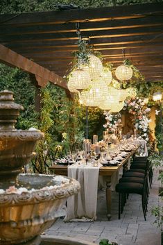 an outdoor dining area with chandeliers and tables set up for a formal function